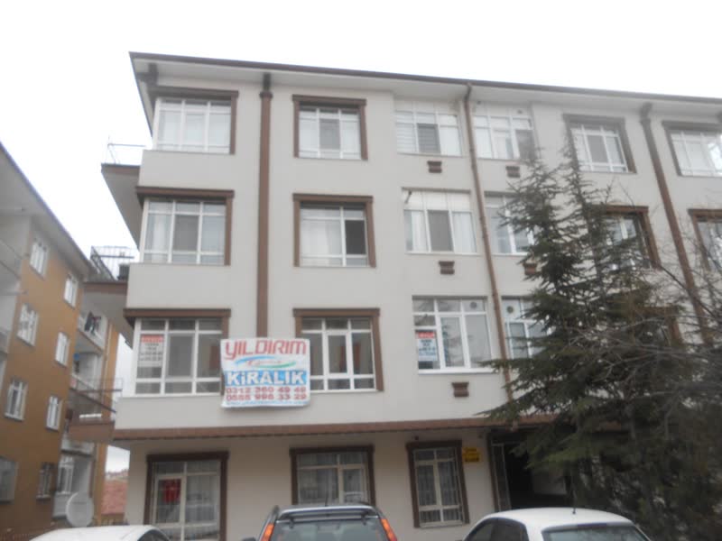 Cephesinde Yıldırım Emlak kiralık afişi olan apartman